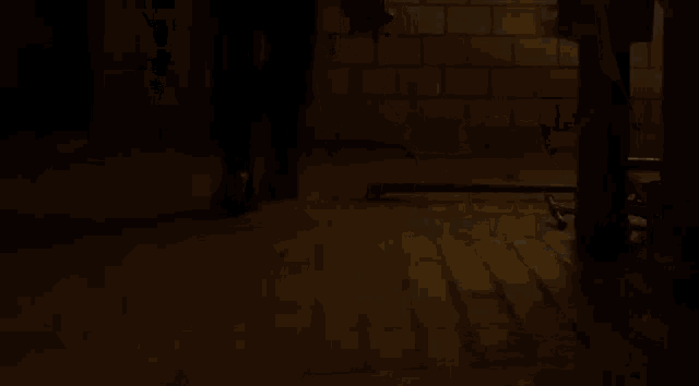 a person is standing in a dark room holding a bottle .