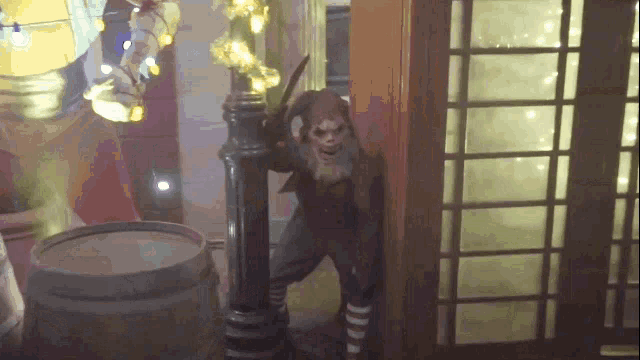 a monkey holding a knife stands next to a barrel
