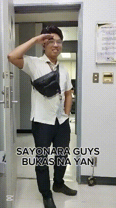a man in a white shirt and black pants salutes while standing in a hallway .