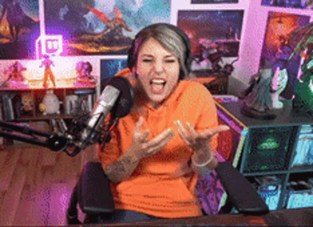 a woman wearing headphones is sitting in front of a microphone and screaming
