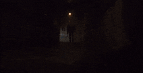 bonnie from five nights at freddy 's is standing in the dark with orange eyes .