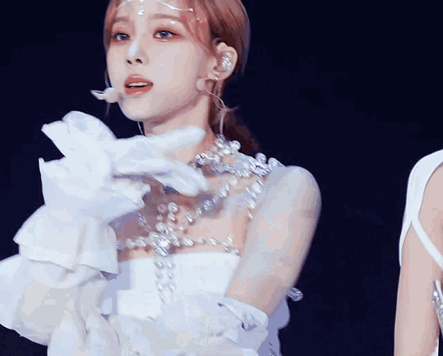 a woman wearing white gloves and a necklace with pearls