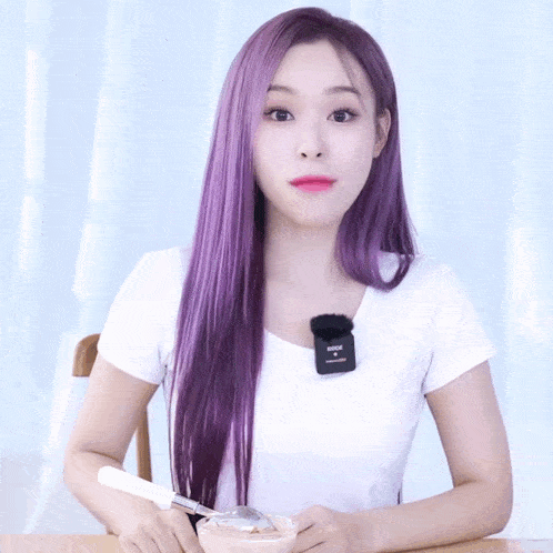 a woman with purple hair is holding a bowl with a spoon