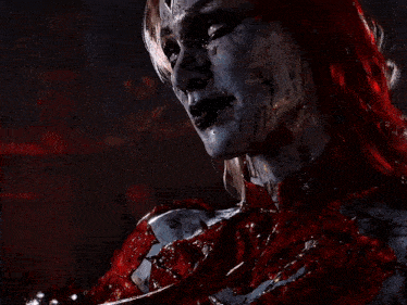 a woman with blood on her face is holding a bloody sword in her mouth