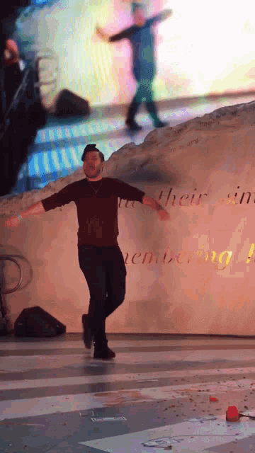 a man is dancing in front of a wall that says their sin remembering it