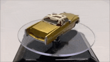 a toy car with a cow print top is sitting on a clear display