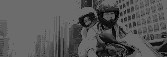 a black and white photo of two people riding a motorcycle .