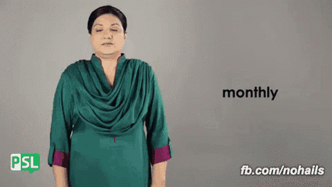a woman in a green dress is making a sign that says monthly .