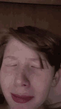 a close up of a person 's face with their eyes closed and red lips