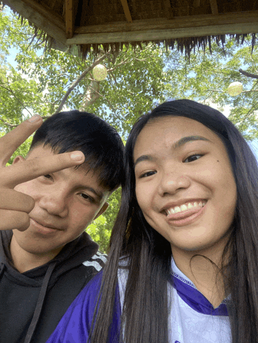 a boy and a girl are posing for a picture and the girl is wearing a shirt that says ' basketball '