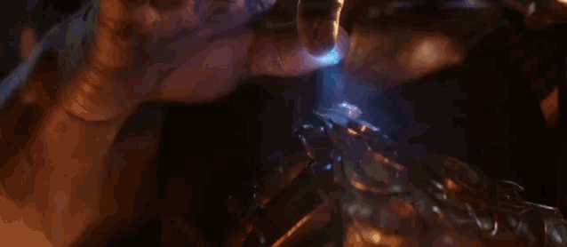 a person is holding a glowing object in their hand in a dark room .