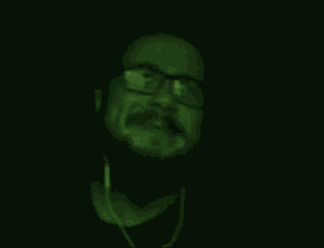 a man with glasses and a beard is making a call me gesture