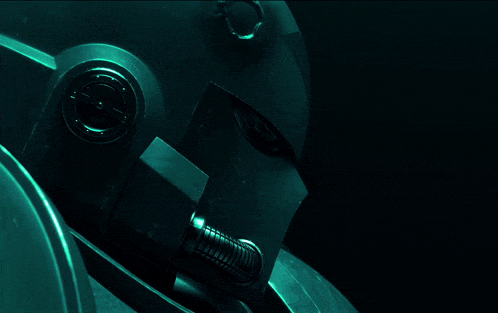 a close up of a robot 's face with a green light shining on it