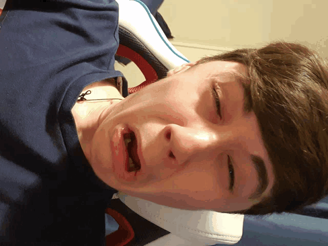 a close up of a young man making a funny face with his eyes closed