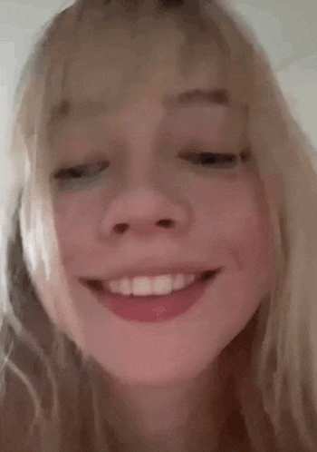 a close up of a woman 's face with her mouth open and a red lip .
