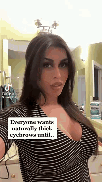 a woman is taking a selfie in front of a mirror .