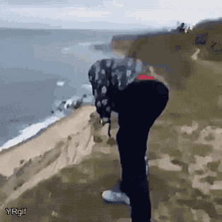 a person is standing on a cliff overlooking the ocean