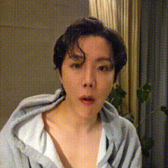 a woman is making a funny face while wearing a hoodie and a white shirt .