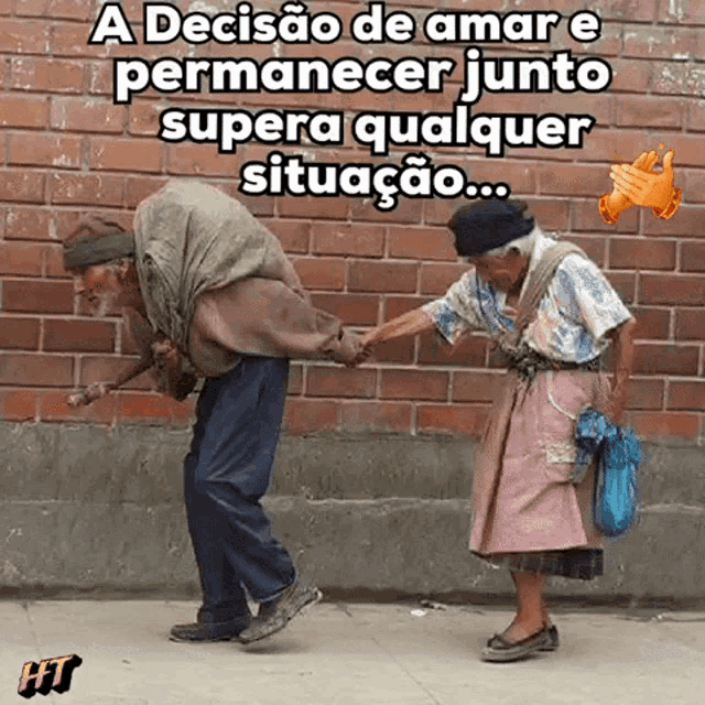 an old couple holding hands in front of a brick wall .