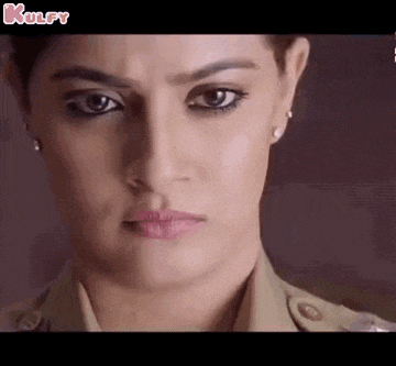 a close up of a woman 's face wearing a police uniform and looking at the camera .