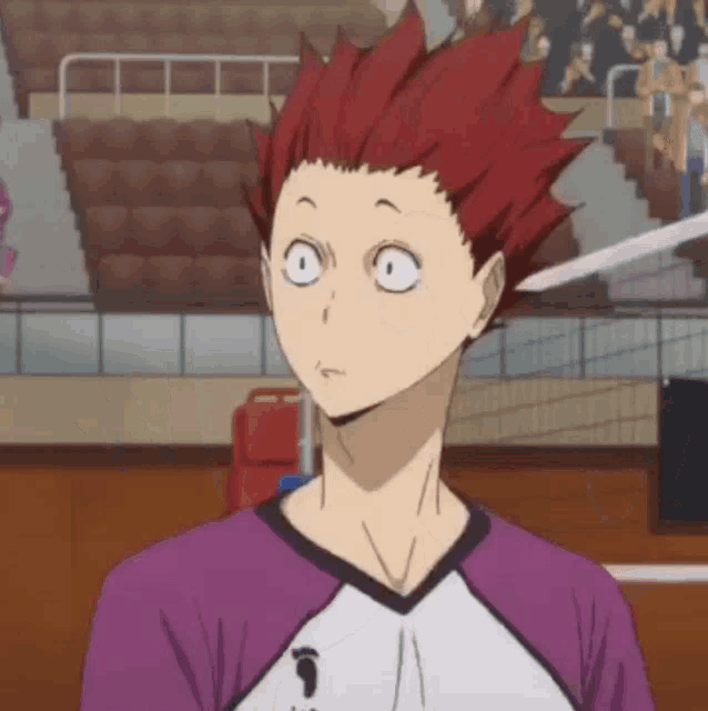 a man with red hair is wearing a purple and white shirt with the letter t on it
