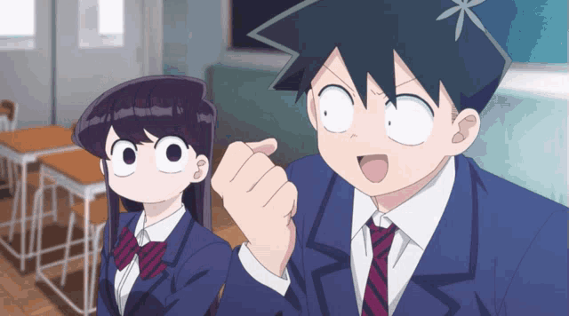 a boy and a girl are sitting in a classroom and the girl is making a funny face