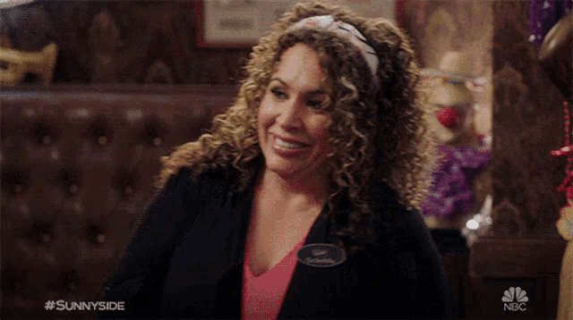 a woman with curly hair is smiling and wearing a name tag that says lisa ortruda