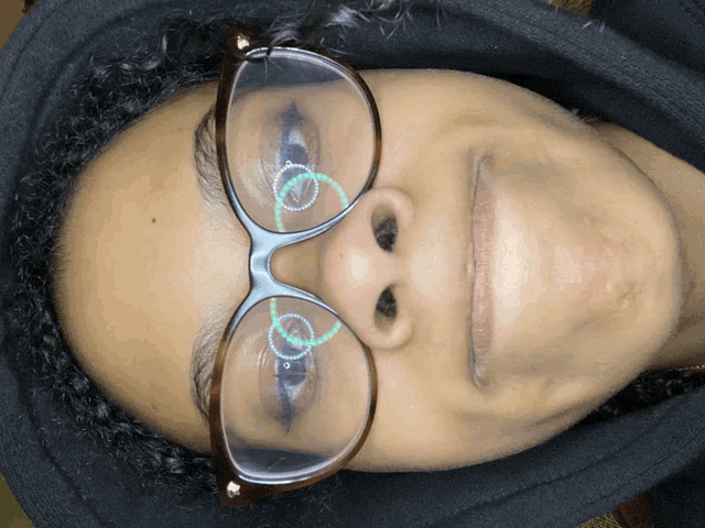 a woman wearing glasses and a black hoodie