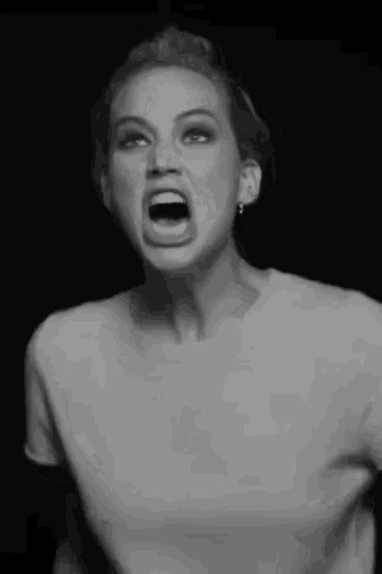 a black and white photo of a woman making a funny face .