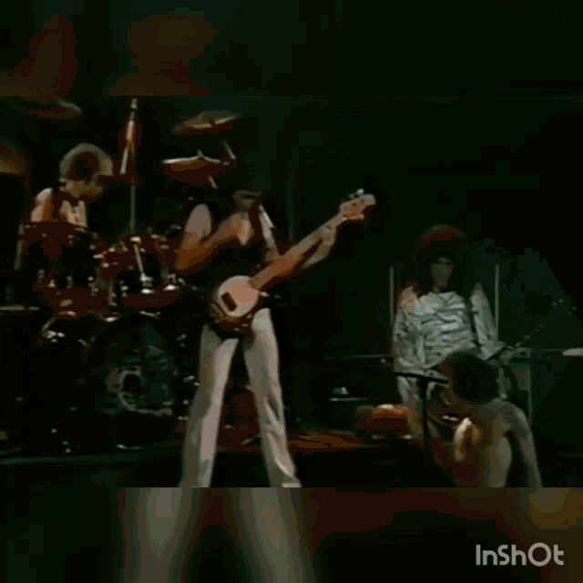 a man without a shirt is holding another man 's hand in a blurry video .