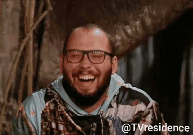 a man with glasses and a beard is laughing with the words tvresidence below him