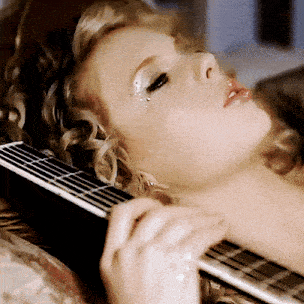 a close up of a woman laying down with her eyes closed