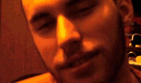 a close up of a man 's face with his eyes closed and a red background .