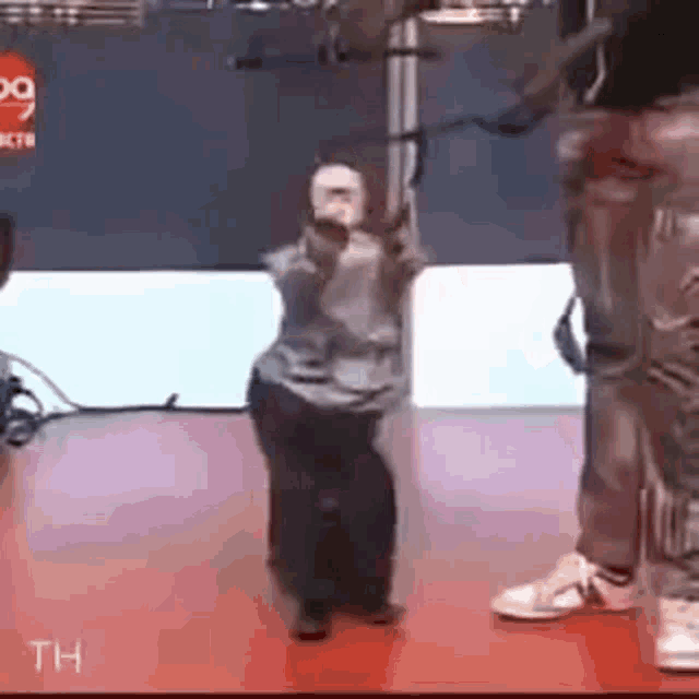 a man is standing next to a robotic monkey on a stage .
