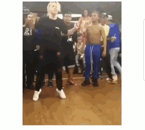 a group of people are dancing on a wooden floor in a dance studio .