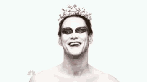 a man with white paint on his face and a crown on his head .