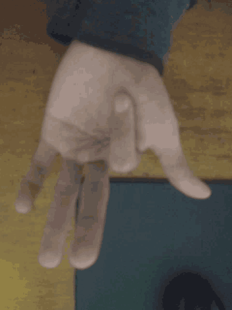 a close up of a person 's hand with the thumb pointing upwards