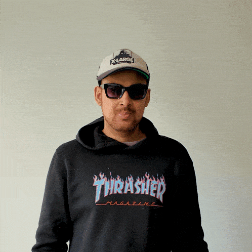 a man wearing a thrasher magazine hoodie and sunglasses