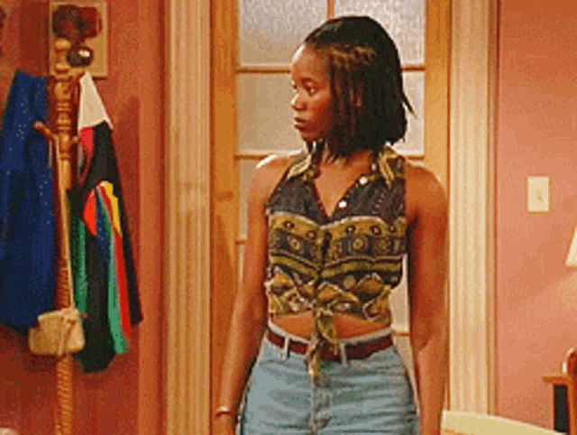 a woman wearing a crop top and shorts is standing in a room