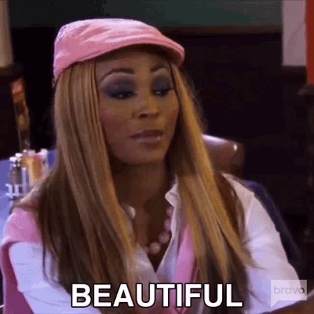 a woman wearing a pink hat and a white shirt is sitting in a diner and says beautiful .