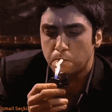 a man lighting a cigarette with the name ismail written on the bottom of the image