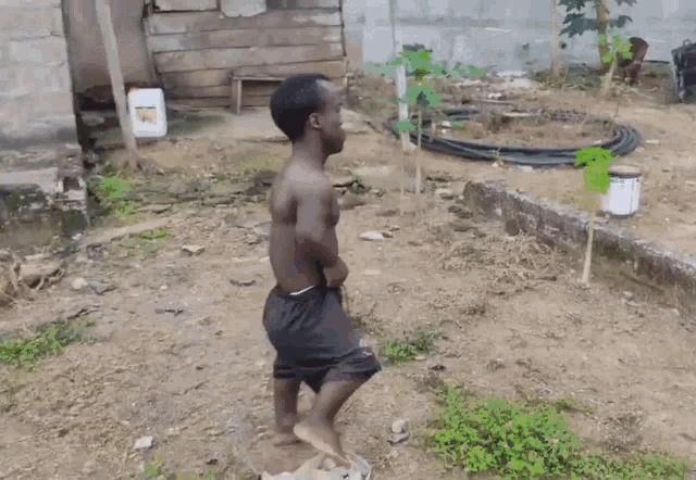 a man without a shirt is standing in the dirt in front of a white container that says ' sd '