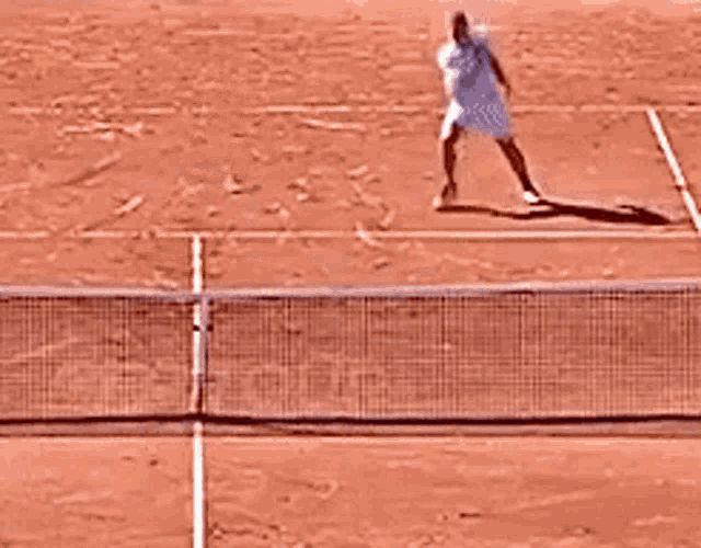 a man playing tennis on a red court