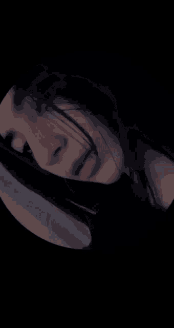 a close up of a woman 's face in a dark room .