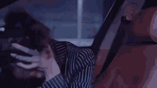 a woman is sitting in the back seat of a car with her hands on her head .