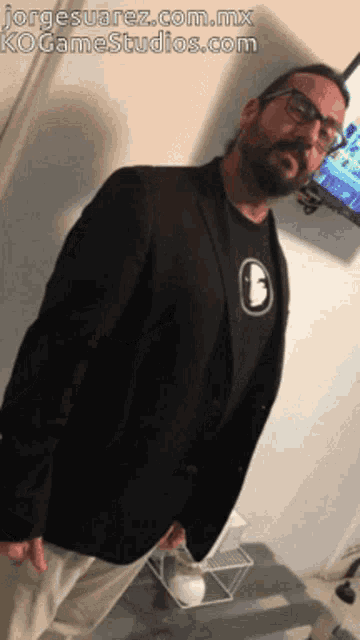 a man standing in front of a tv with jorge suarez.com.mx ko gamestudios.com written below him