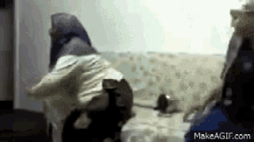 a group of people are sitting on a couch and one of them is wearing a hooded jacket .