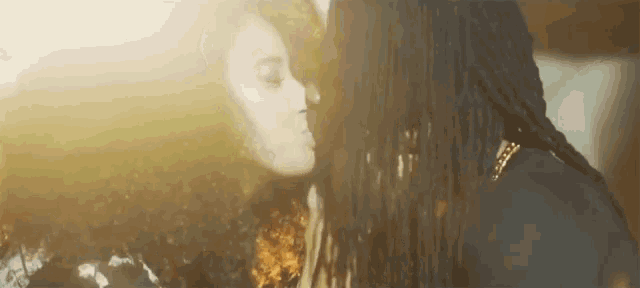 a man and a woman are kissing each other in front of a window .