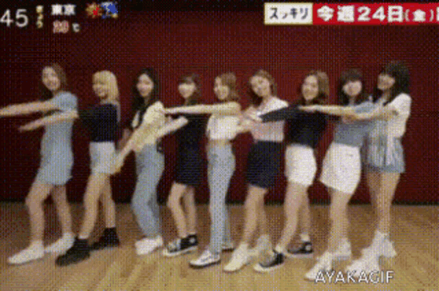 a group of young women are standing in a row on a stage .