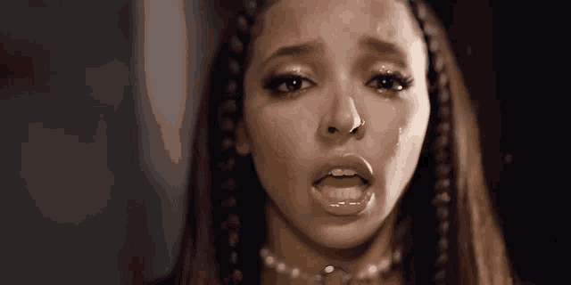 a close up of a woman with tears running down her face .